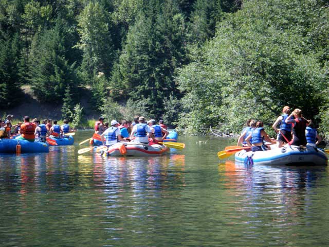 Dozen kayaks going down the river