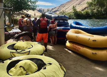 Stacks of rafts sit next to the lower yakima river along with stacks of inflated tubes.